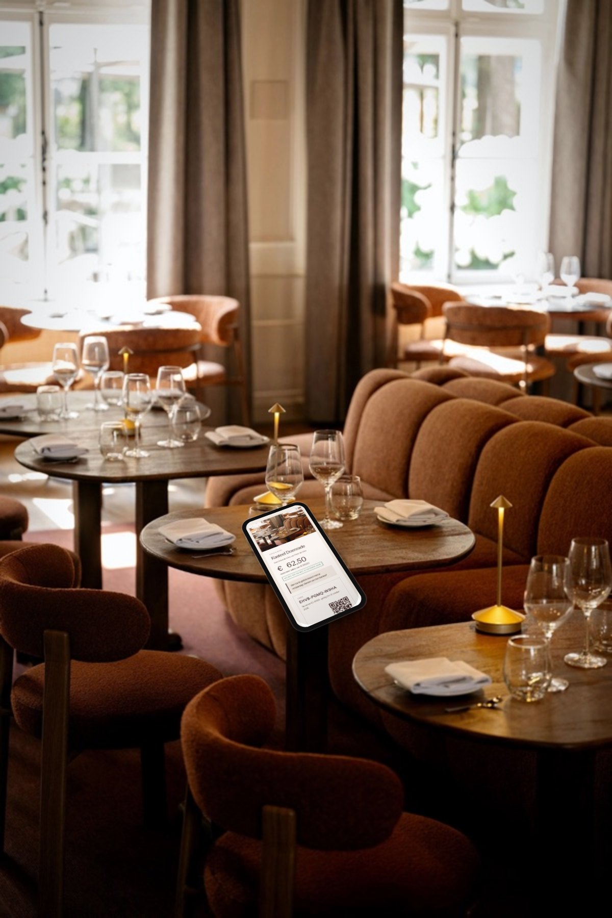 Een telefoon op een gedekte tafel in het restaurant van Kasteel Doenrade met de bonpagina van de gast: saldo, code en QR